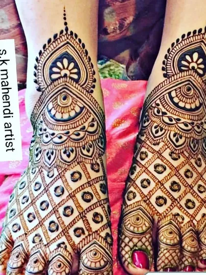 A classic foot mehendi design with full coverage over the top of the feet. The pattern is symmetrical and features a beautiful central motif, perfect for a bride or for a festival.