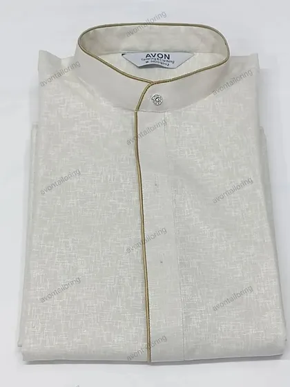 This off-white textured kurta is paired with a subtle golden piping. It is sold as a complete set with a matching saya and izaar.