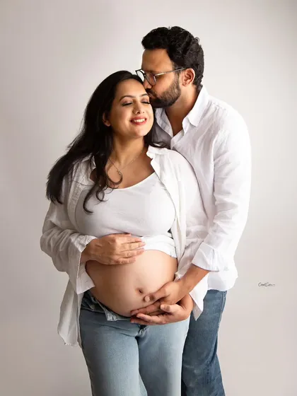 Sometimes the simplest moments are the most powerful. This casual couple's maternity shoot, with both parents-to-be in simple white shirts and jeans, focuses entirely on their loving connection and the beautiful baby bump.