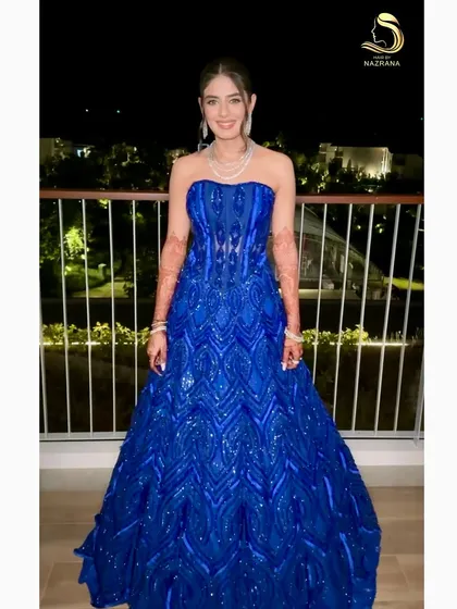 The bride looking like a princess in her royal blue gown, with a sleek ponytail to complete the look.