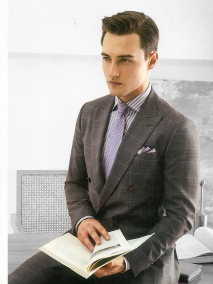 A classic double-breasted suit in grey plaid, paired with a lavender shirt. This demonstrates our ability to create sophisticated business attire that is both timeless and modern.
