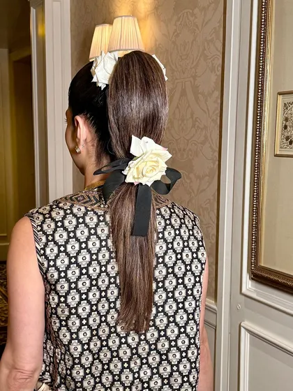 A detail shot of a chic hairstyle from a look I created for India Couture Week. The sleek ponytail with fresh flowers and a ribbon is a perfect example of modern, elegant styling.