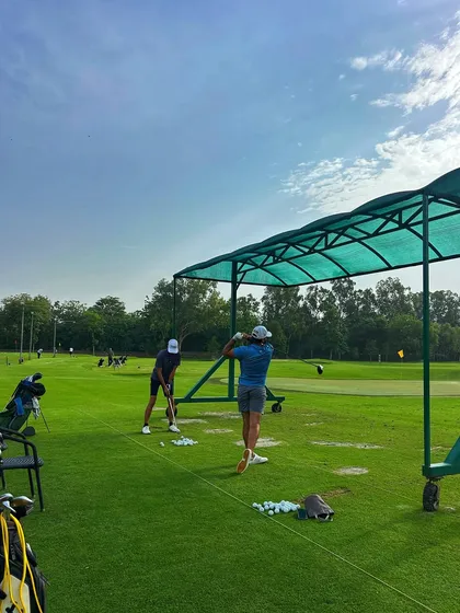 Two golfers practice side-by-side under the shade of our canopies on a bright, sunny day.