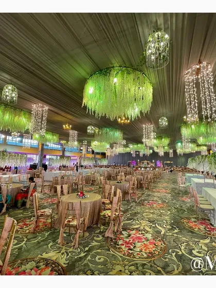 The dining area setup for 'The Bhosale Wedding'. We used custom-printed carpets and hanging floral installations with crystal chandeliers to create an enchanting garden-like atmosphere for the meal service.