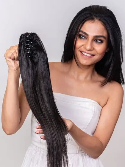 Our clutch ponytail is designed for instant transformation. This model is holding the extension, which features an easy-to-use clutch clip for secure and quick application.