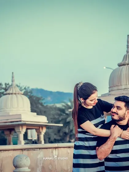 A playful and casual moment in matching outfits, with the classic architecture of Jaipur providing a beautiful backdrop.