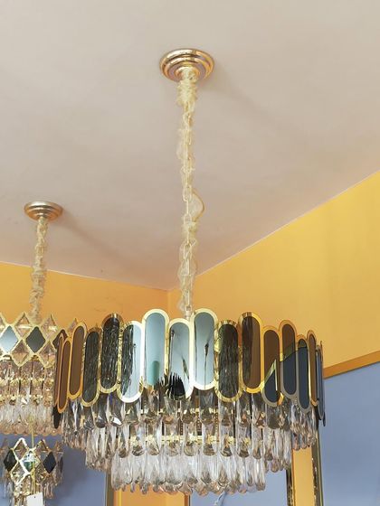 A classic drum chandelier with a modern update, featuring a frame of colored and clear crystal panels.