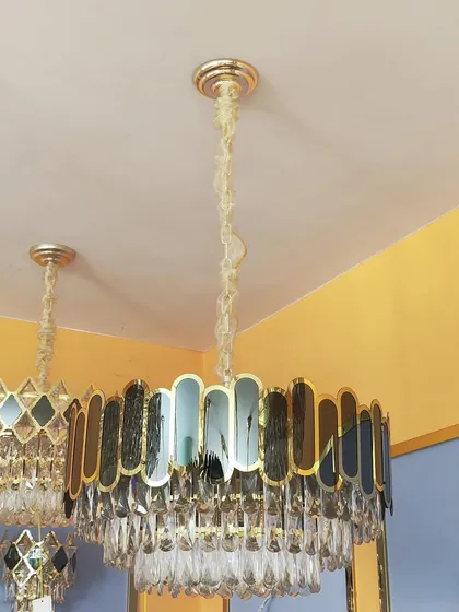 A classic drum chandelier with a modern update, featuring a frame of colored and clear crystal panels.