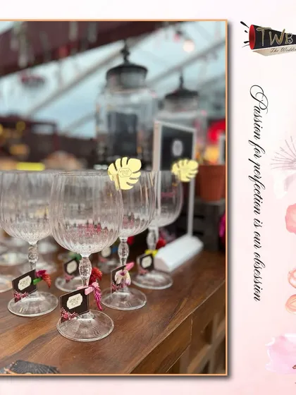 Elegant crystal glassware adorned with custom tags and tropical-themed stirrers for a destination event in Udaipur.