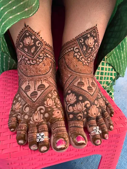 A stunning feet design with lotus and jhumka motifs. The bride's toe rings add a lovely finishing touch to the overall look.