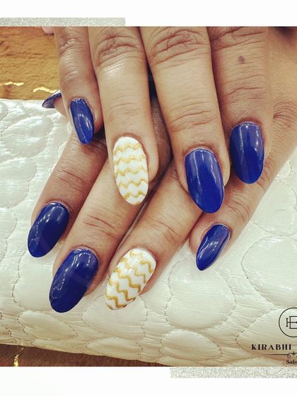 A classic color combination of royal blue and white. The accent nails feature a wavy gold pattern for a touch of elegance and visual interest.