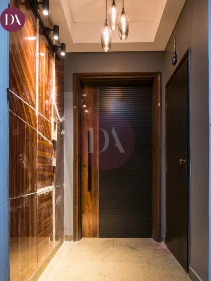 A view of a modern entryway with a striking backlit marble panel and a sleek, contemporary door. This shows our attention to detail in creating impressive transitional spaces.