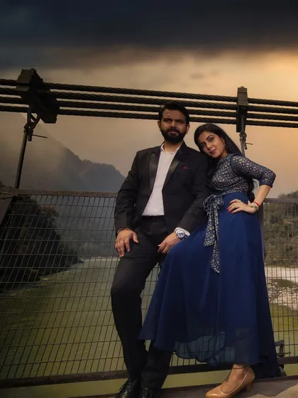 A dramatic pre-wedding portrait on a bridge in Rishikesh. The moody sky and the majestic mountains in the background add a sense of grandeur and adventure to their love story.