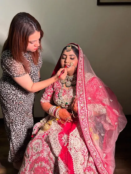 A behind-the-scenes shot of me working on the lovely bride, Dipika. Here, I am carefully applying her lipstick to create the perfect pout.