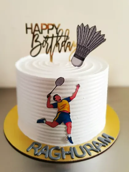 A clean and simple badminton themed cake, perfect for a player's birthday. It features a racket, shuttlecock, and a player in action.