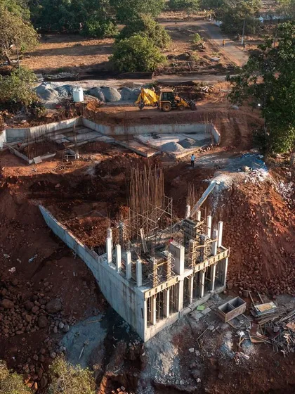 This is a glimpse of the Sea Sky Villas under construction, a project deeply rooted in its natural surroundings. The challenging hillside terrain was not an obstacle, but an inspiration. The design works with the land's topography, weaving the structure into the environment to create a unique living experience with uninterrupted views.
