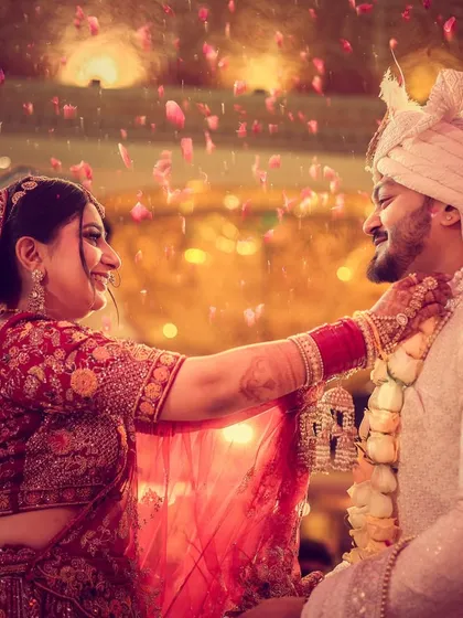The bride placing the garland on the groom during the varmala ceremony, a moment of mutual respect and acceptance.