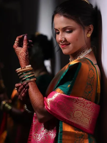 A beautiful candid moment. The lighting catches the rich colors of her saree and the subtle glow of her makeup, showing how my work looks stunning from every angle.