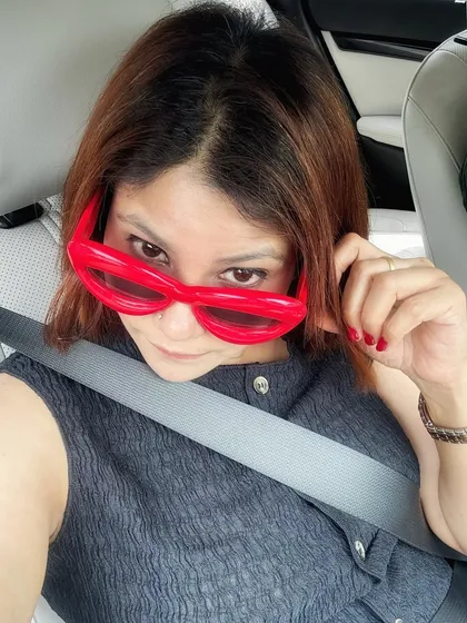 Accessories can be the main event. These quirky, oversized red sunglasses add a dose of fun and chaos to an otherwise calm and neutral outfit, proving that a single accessory can change your entire vibe.