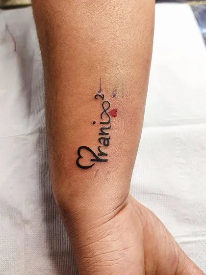 A name tattoo with an infinity symbol. This design represents eternal love and connection.