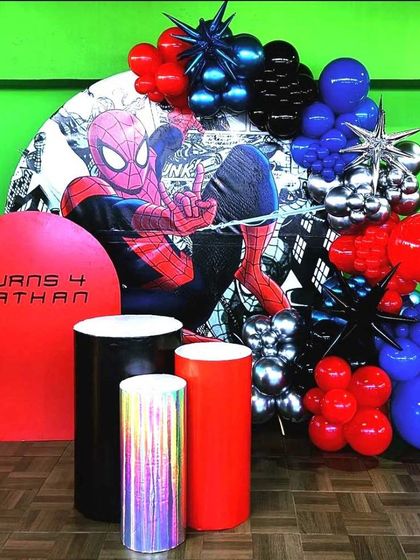 A modern and graphic Spiderman theme for a 4th birthday. This unique setup uses a comic-book style backdrop and spiky starburst balloons for a high-impact look.
