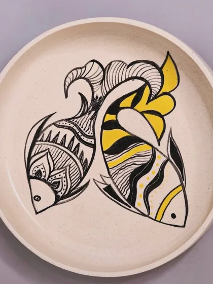 A full view of the sold fish plate with yellow accents. Each hand-painted plate adds a touch of charm and creativity to your space, telling its own unique story.