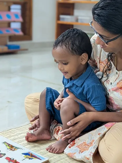 I believe in a gentle start. A parent sits with their child, offering comfort and support as he explores a new puzzle. This partnership is key to building a bridge of trust between home and school.