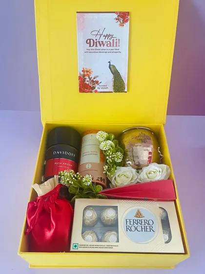 Inside the yellow box, a premium hamper with Davidoff coffee, Ferrero Rocher, a scented candle, and other luxury items.