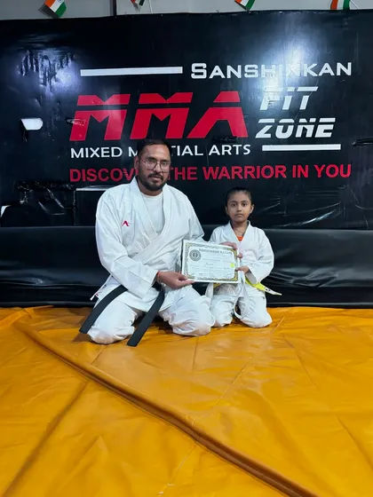 A sensei presenting a certificate and new belt to a young karate student. Each belt promotion is a celebration of progress and commitment.
