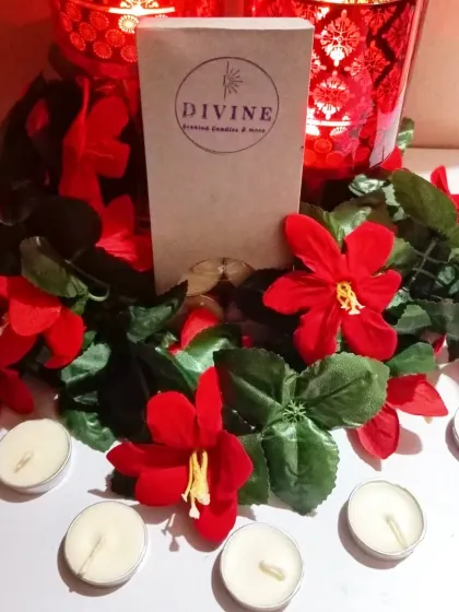 My unscented tealight pack, displayed in a festive setting with red flowers. They are perfect for adding light to any decor without competing fragrances.