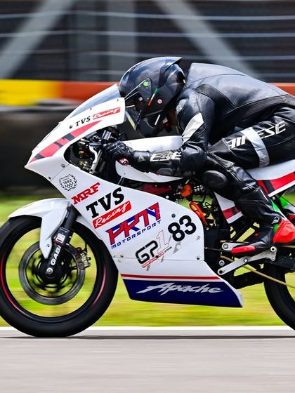 A side profile of Siddesh at speed, showing his aggressive riding posture on the Pro Stock race bike.