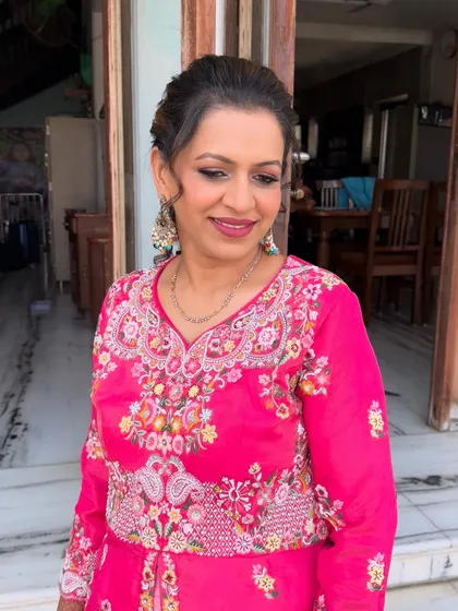 This client is glowing in her bright pink outfit. I used a soft brown smokey eye and a matching pink lip to create a balanced and festive look.