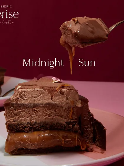 A close-up of the Midnight Sun, where you can see the gooey caramel layer beneath the rich chocolate mousse. This is a dessert for those who appreciate true decadence.