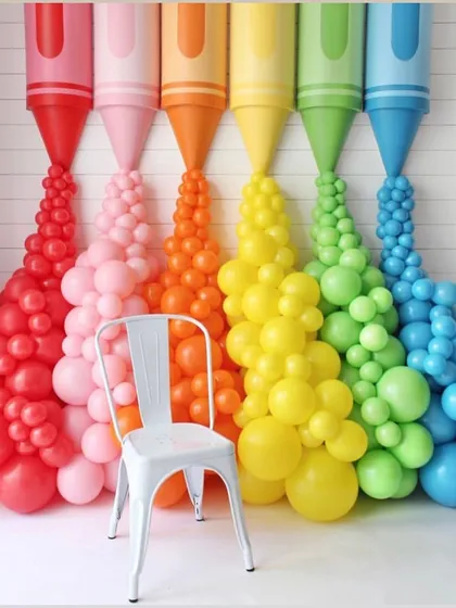 A colorful and creative photo backdrop made of giant crayons with balloon "paint" pouring out. This is a perfect interactive spot for guests at an art-themed party or a back-to-school event.
