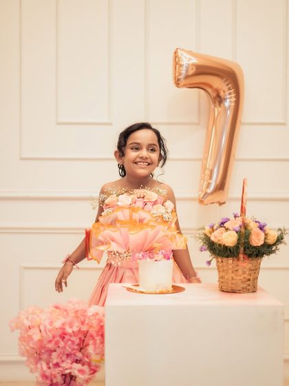 A beautiful smile for her 7th birthday portrait. This session features a lovely floral theme with a custom dress, cake, and a large number '7' balloon.