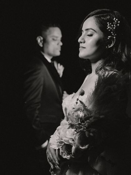An artistic low-light portrait of the couple. This black and white image uses shadow and light to create a moody, intimate, and highly stylized photograph.