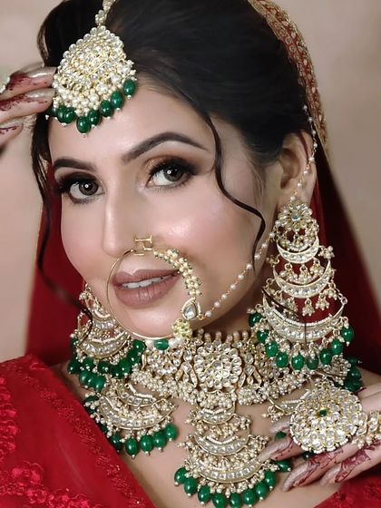 A grand, chandbali-style bridal set with heavy green beading and red accents. This is a statement piece that is sure to turn heads.