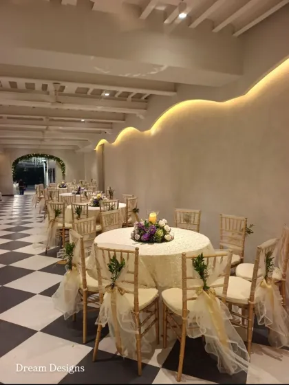 The indoor dining area at Colaba Agiary, where I continued the theme of classic elegance. The checkered floor is complemented by round tables with floral centerpieces and Chiavari chairs dressed in delicate organza.