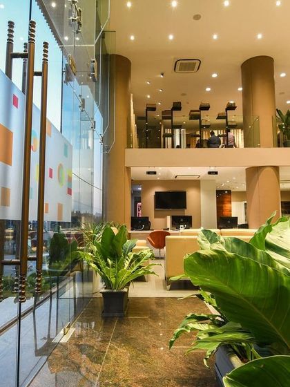 A comprehensive look at a conventional commercial space, highlighting the double-height reception, glass-walled mezzanine, and various product display areas designed for a modern business.