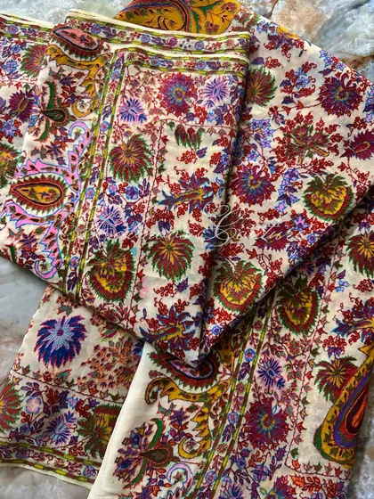 A folded view of the dupatta, showcasing the layers of color and pattern. The taupe base provides a perfect canvas for the brilliant floral and paisley art.