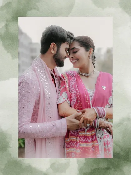 An intimate and joyful moment captured in a soft, artistic frame. The couple's genuine smiles and close embrace in their beautiful pink traditional outfits make this a heartwarming shot.