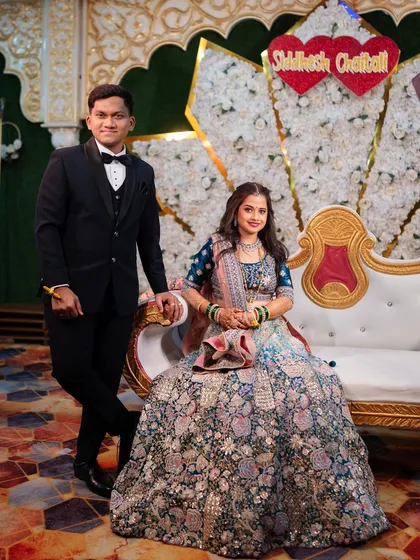 Another classic pose on the reception stage, showcasing the couple's beautiful reception outfits.
