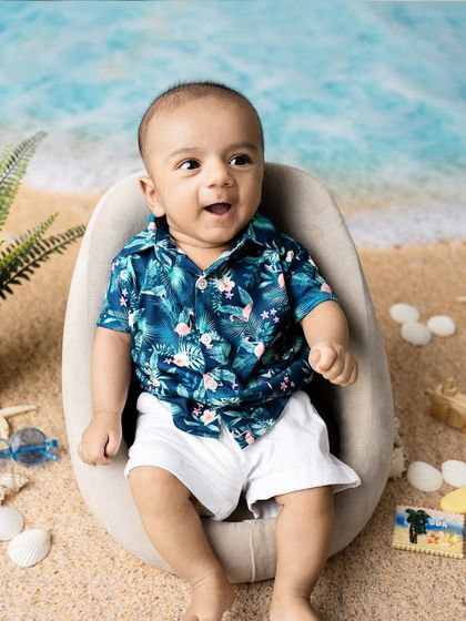 A big, happy smile from our beach baby. The vibrant colors and fun props make this a joyful and memorable portrait.