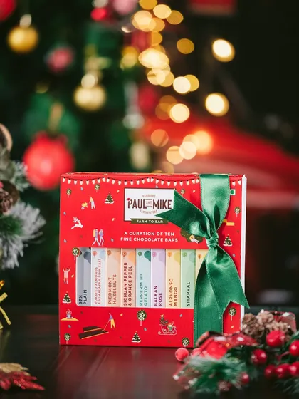 A beautifully packaged Christmas chocolate box set against a backdrop of twinkling lights. This shot shows how to create a warm, gift-giving atmosphere for holiday-themed product videography.