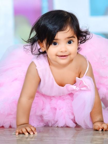 A precious moment of the birthday girl crawling in her beautiful pink dress. We capture milestones big and small.