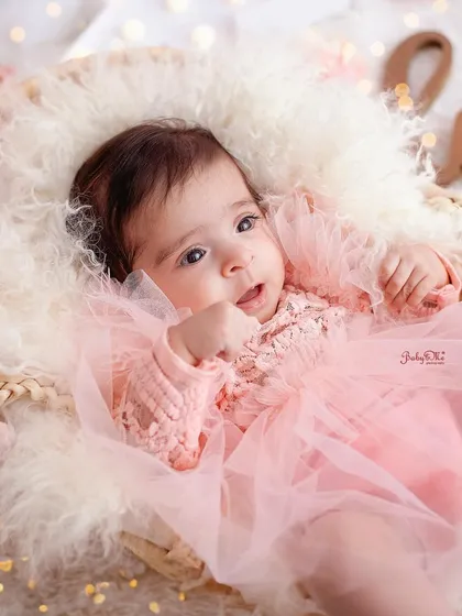 This little princess is wide awake and happy in her pretty pink dress. Her bright eyes and sweet expression are the focus of this beautiful portrait.