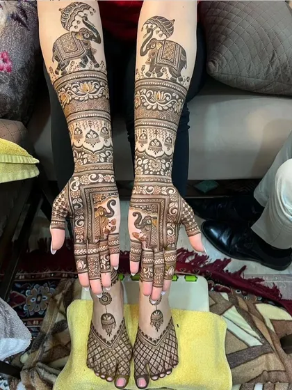 This full-body design features majestic elephants on the arms and feet, creating a symmetrical and regal look. The net-like pattern on the feet is a classic choice.