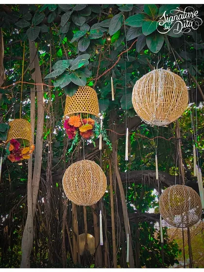 For the Mexican theme, I hung woven basket lanterns and floral arrangements from the trees, creating a rustic and natural lighting effect.