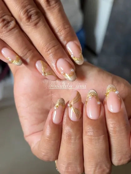 An elegant pearl chrome design with delicate gold lines and tiny pearl accents. This is a perfect inspo for your next nail service.