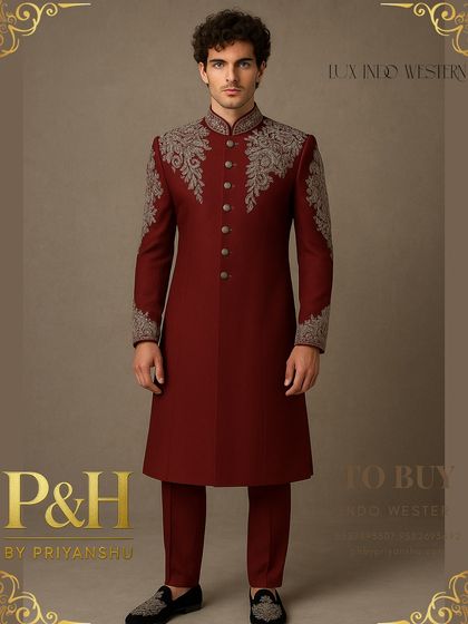 A magnificent Indo-Western suit in a deep red, featuring dense silver hand-embroidery on the shoulders and cuffs. This piece is designed for a groom who wants to make a grand, royal entrance.